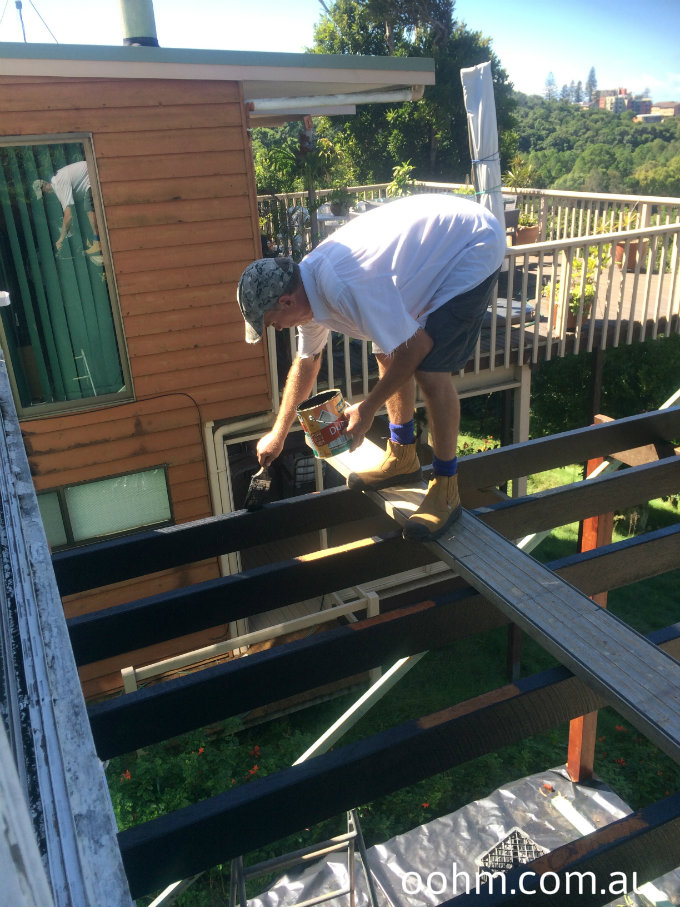 Painting the underside of the top storey deck ready to lay timber decking