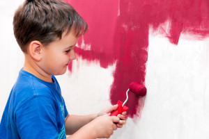 boy painting the wall red